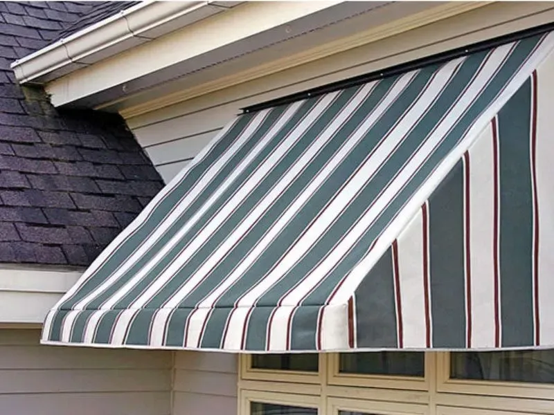 A green and white striped awning on the side of a house