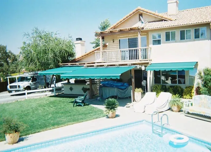 A large house with a swimming pool in front of it