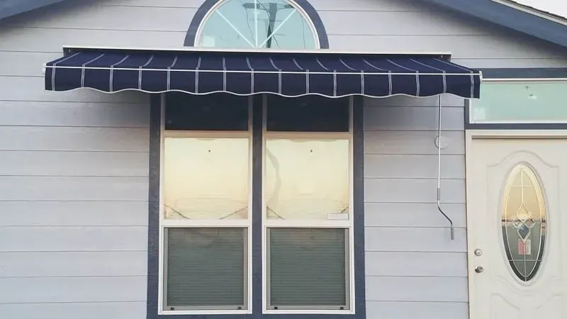 A house with a blue awning over a window.
