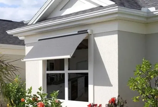 A white house with a window with an awning on it